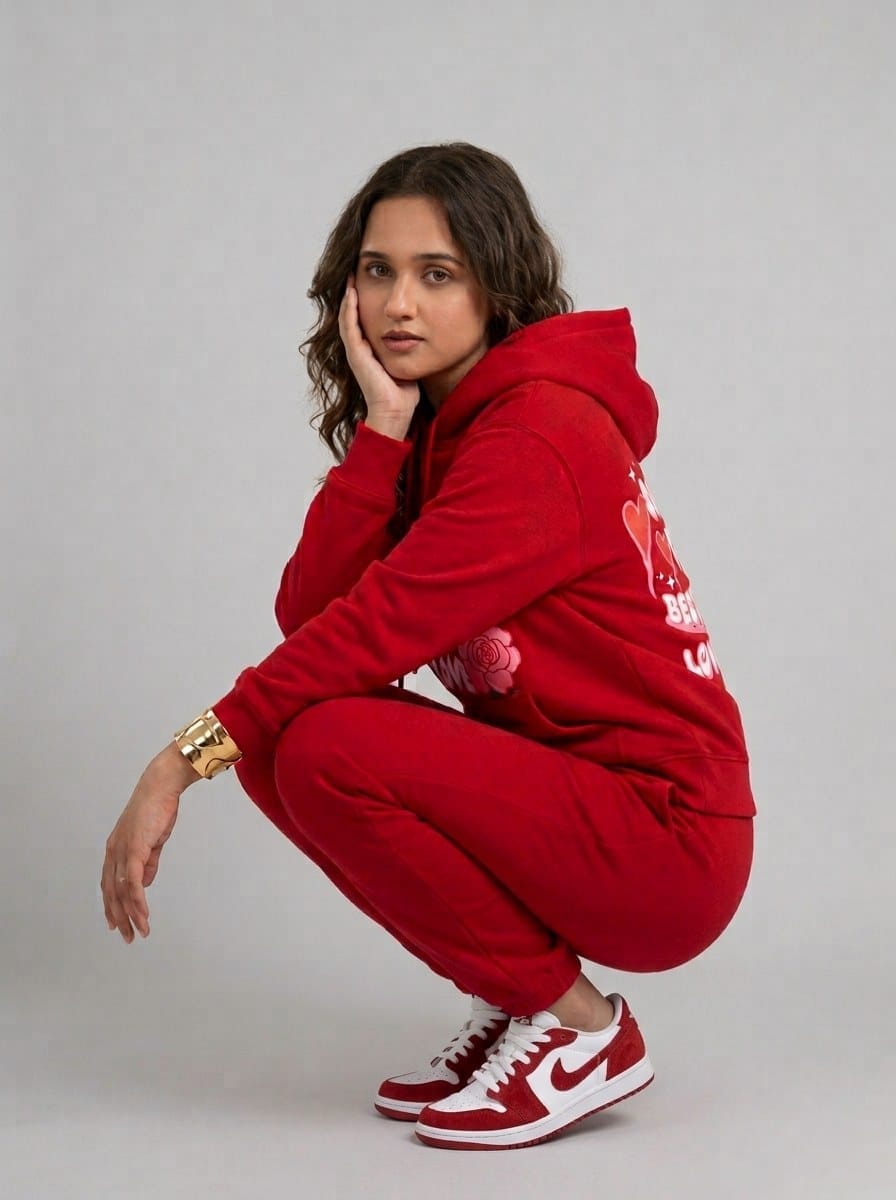 Female model crouching in the ZYVRO Star Heart red fleece tracksuit